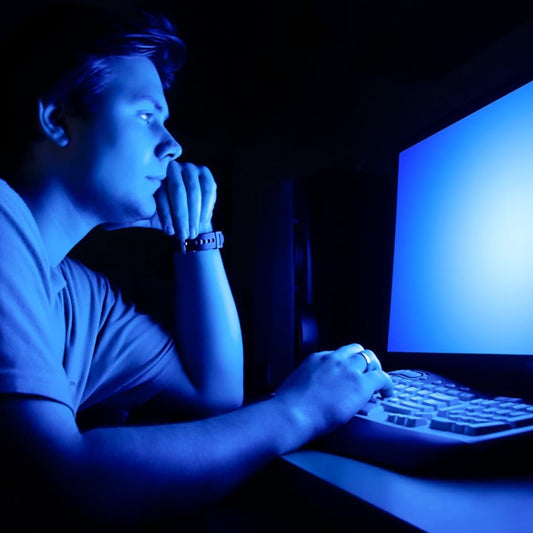 Man staring at bright computer screen late at night – blue light disrupting sleep patterns and focus.